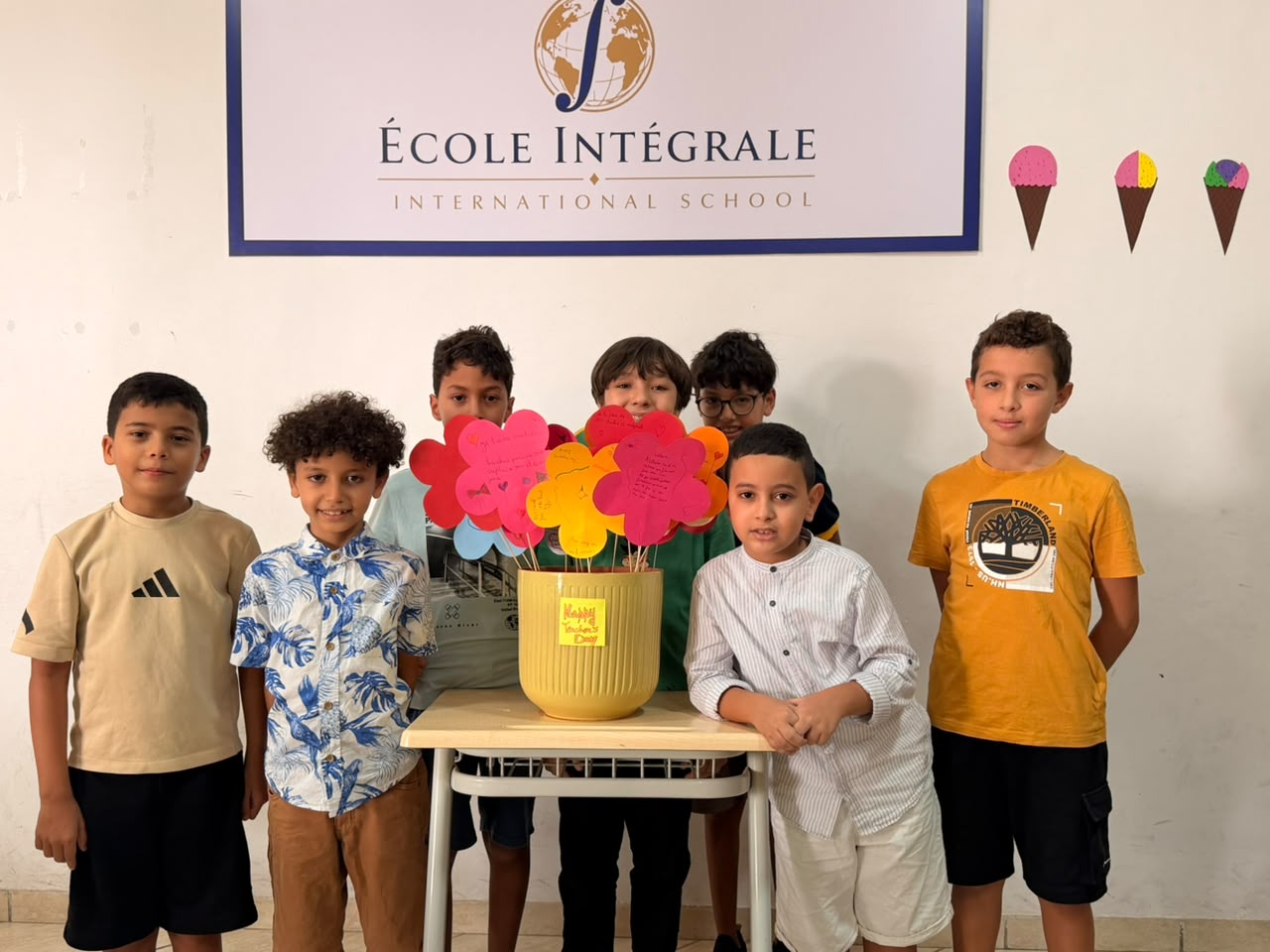 Élèves réunis devant le panneau de l'école pour un événement